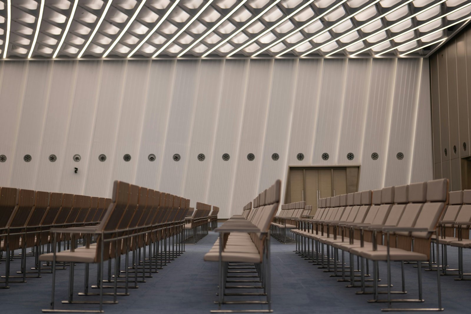 Athens 2026 conference delegates using spatial audio headsets for a silent keynote session in a biophilic meeting space.