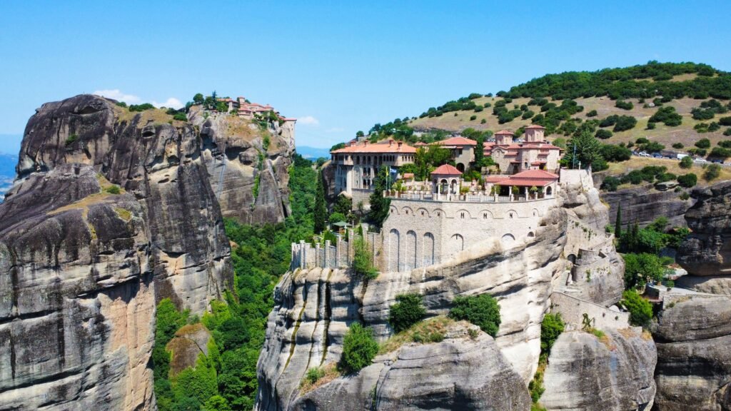 Stunning aerial landscape of the Meteora monasteries perched atop dramatic cliffs in Kalampaka, Greece.