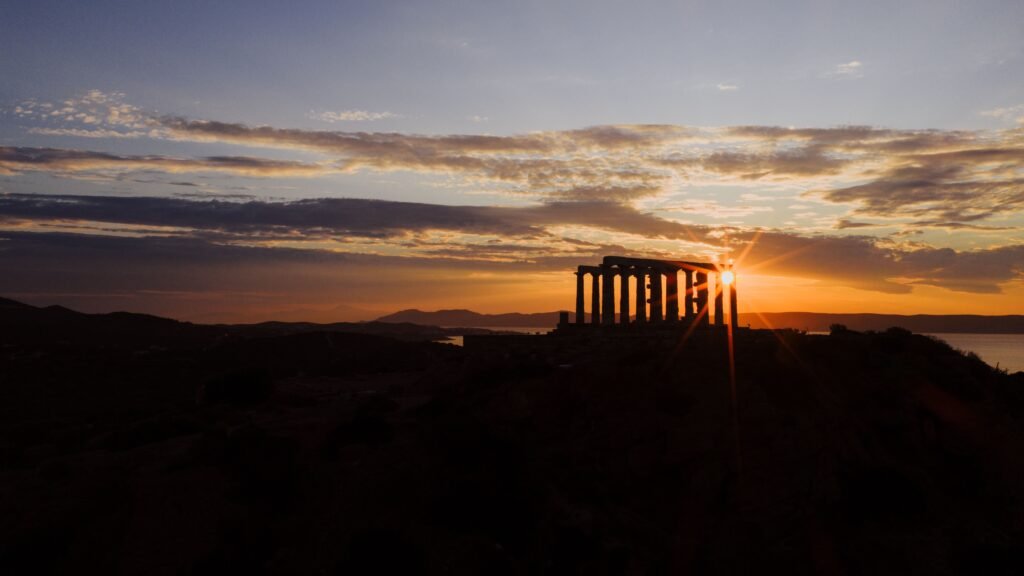 Breathtaking sunset at the Temple of Poseidon in Sounion, Greece, with vibrant skies.